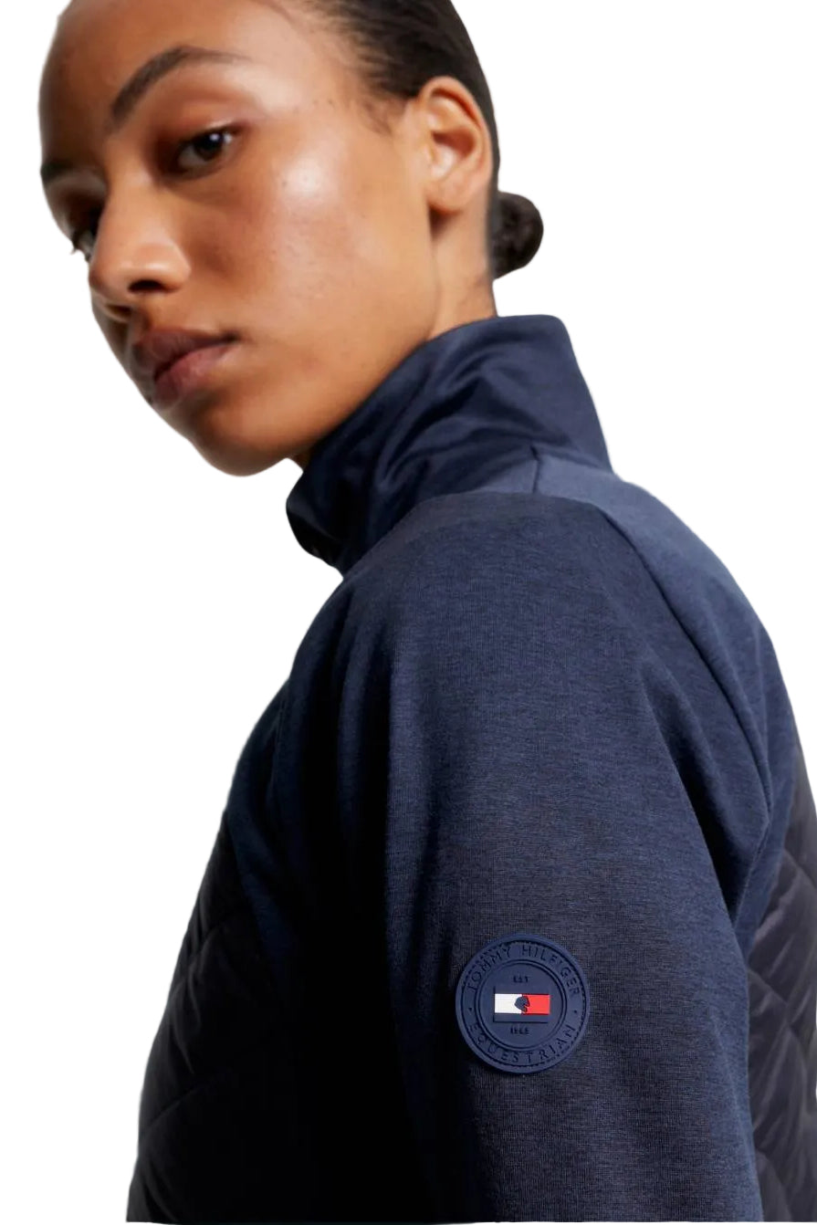 Damen-Hybridjacke von Tommy Hilfiger mit der Bezeichnung "Hybridjacke TH08WJAC454-004" in der Farbe Blau. Diese Hybridjacke ist auf der Webseite www.hotti24.de erhältlich. Sie wurde speziell für Damen entworfen, um sowohl Stil als auch Funktionalität zu bieten. Zusätzlich sind in der Datei Bilder der Hybridjacke aus verschiedenen Blickwinkeln enthalten: von vorne, von der Seite und von hinten.