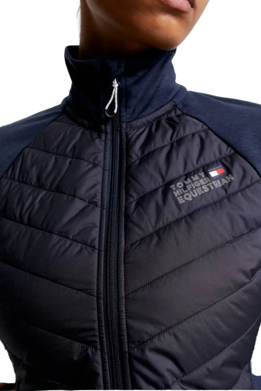 Damen-Hybridjacke von Tommy Hilfiger mit der Bezeichnung "Hybridjacke TH08WJAC454-004" in der Farbe Blau. Diese Hybridjacke ist auf der Webseite www.hotti24.de erhältlich. Sie wurde speziell für Damen entworfen, um sowohl Stil als auch Funktionalität zu bieten. Zusätzlich sind in der Datei Bilder der Hybridjacke aus verschiedenen Blickwinkeln enthalten: von vorne, von der Seite und von hinten.