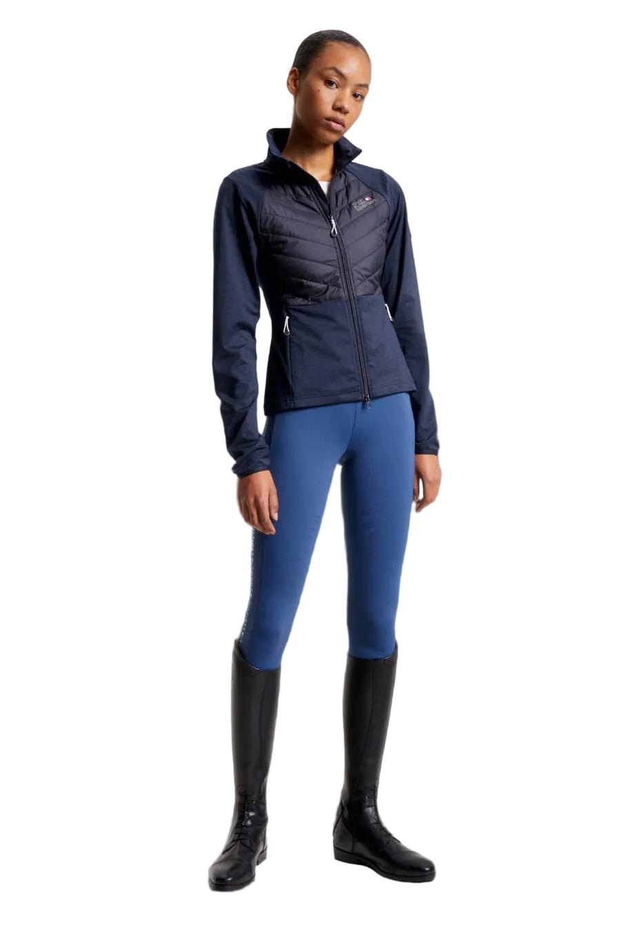 Damen-Hybridjacke von Tommy Hilfiger mit der Bezeichnung "Hybridjacke TH08WJAC454-004" in der Farbe Blau. Diese Hybridjacke ist auf der Webseite www.hotti24.de erhältlich. Sie wurde speziell für Damen entworfen, um sowohl Stil als auch Funktionalität zu bieten. Zusätzlich sind in der Datei Bilder der Hybridjacke aus verschiedenen Blickwinkeln enthalten: von vorne, von der Seite und von hinten.