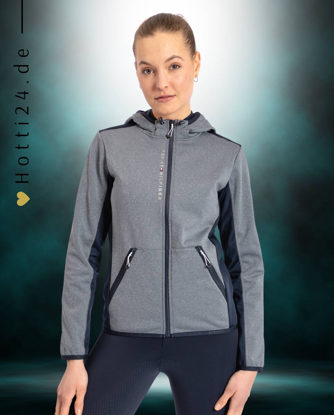 Damen-Jacke im Softshell-Stil von Tommy Hilfiger mit der Bezeichnung "Softshell Jacke London TH08WJAC451-027" in der Farbe Grau. Diese Softshell-Jacke ist auf der Webseite www.hotti24.de erhältlich. Sie wurde speziell für Damen entworfen, um sowohl Stil als auch Schutz vor den Elementen zu bieten. Zusätzlich sind in der Datei Bilder der Softshell-Jacke aus verschiedenen Blickwinkeln enthalten: von vorne, von der Seite und von hinten
