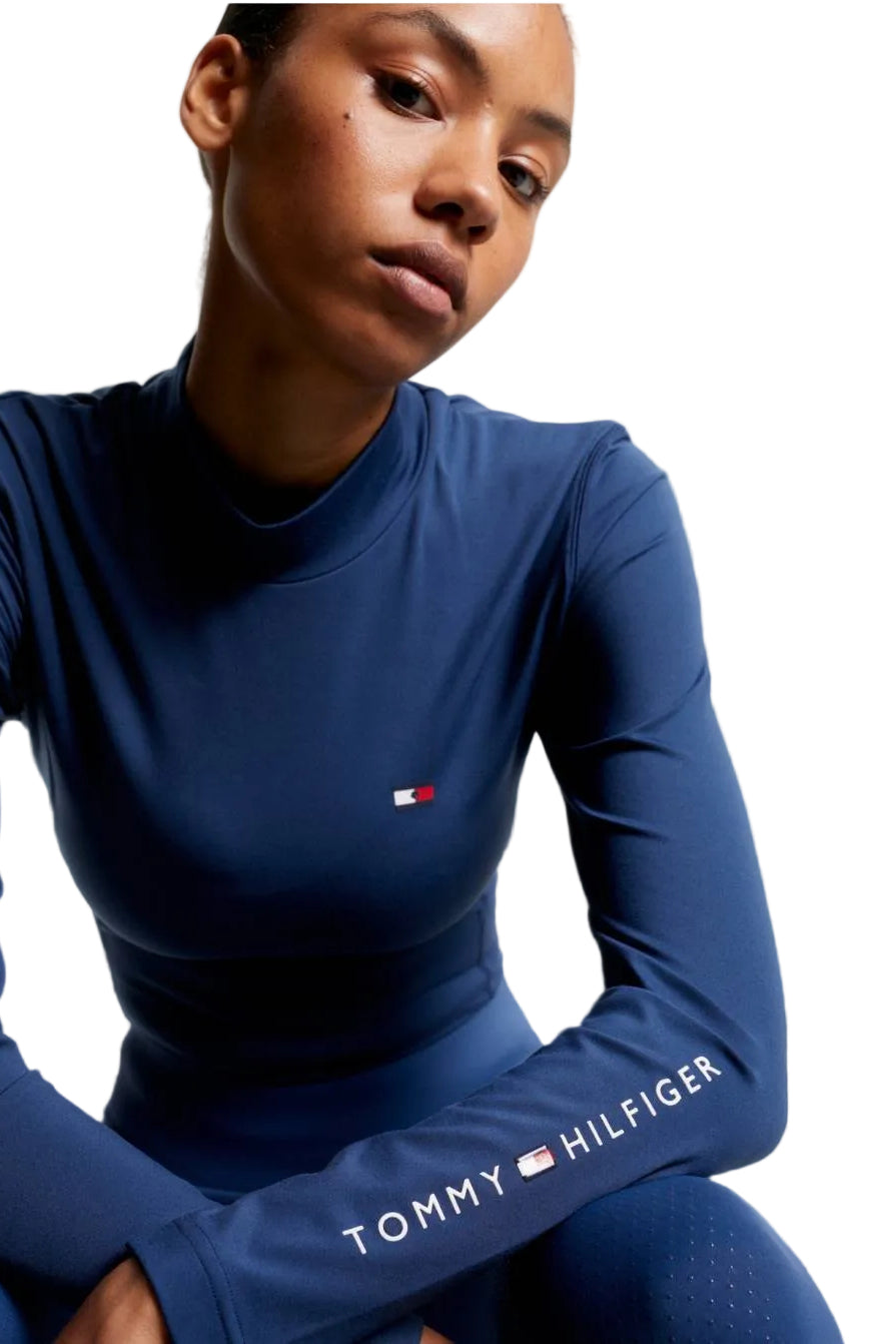 Damen-Trainingshirt von Tommy Hilfiger mit der Bezeichnung "Baselayer TH08WLST432-041" in der Farbe Blau. Dieses Trainingshirt ist auf der Webseite www.hotti24.de erhältlich. Es wurde speziell für Damen entworfen, um Stil und Komfort während sportlicher Aktivitäten zu bieten. Zusätzlich sind in der Datei Bilder des Trainingsshirts aus verschiedenen Blickwinkeln enthalten: von vorne, von der Seite und von hinten.