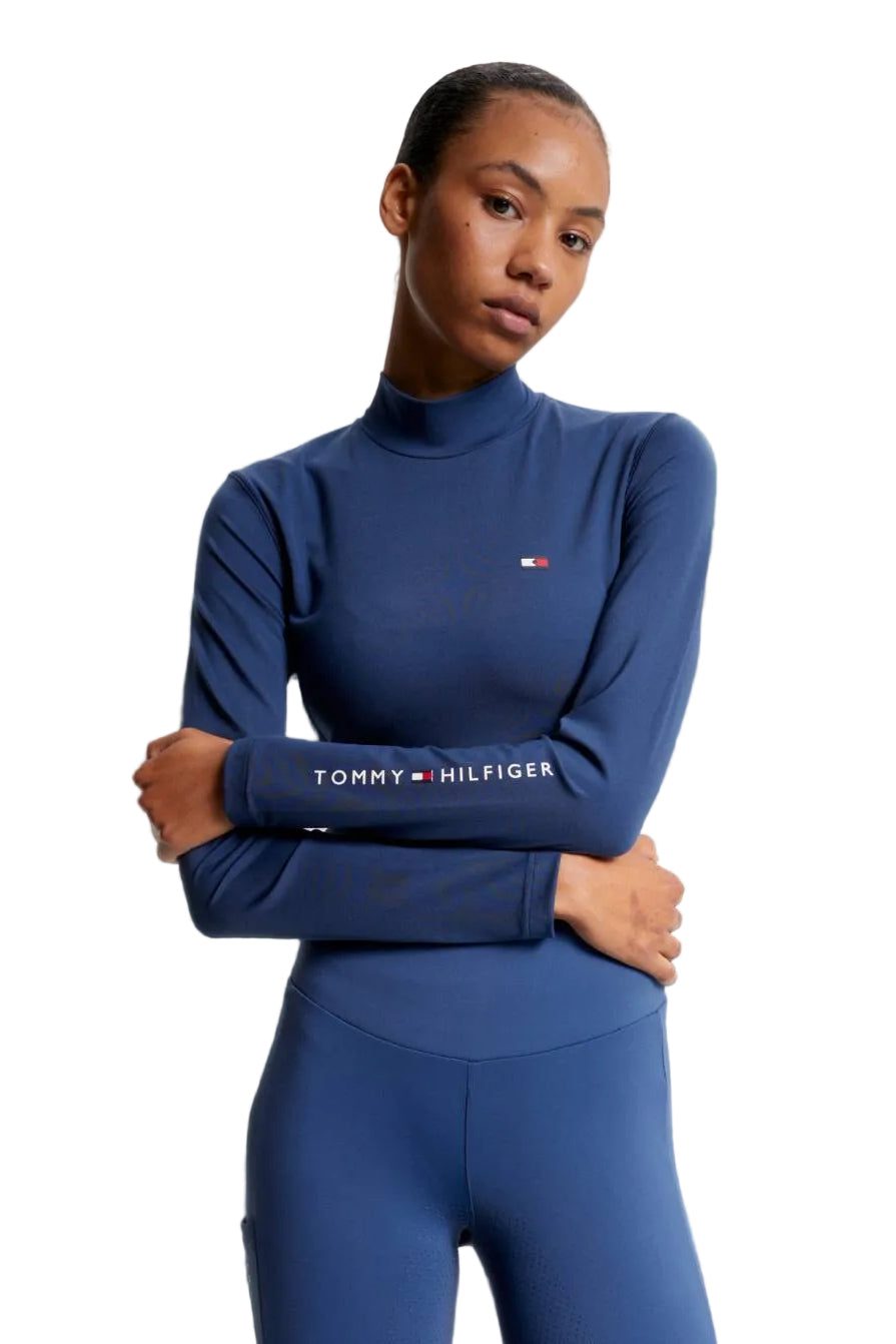 Damen-Trainingshirt von Tommy Hilfiger mit der Bezeichnung "Baselayer TH08WLST432-041" in der Farbe Blau. Dieses Trainingshirt ist auf der Webseite www.hotti24.de erhältlich. Es wurde speziell für Damen entworfen, um Stil und Komfort während sportlicher Aktivitäten zu bieten. Zusätzlich sind in der Datei Bilder des Trainingsshirts aus verschiedenen Blickwinkeln enthalten: von vorne, von der Seite und von hinten.