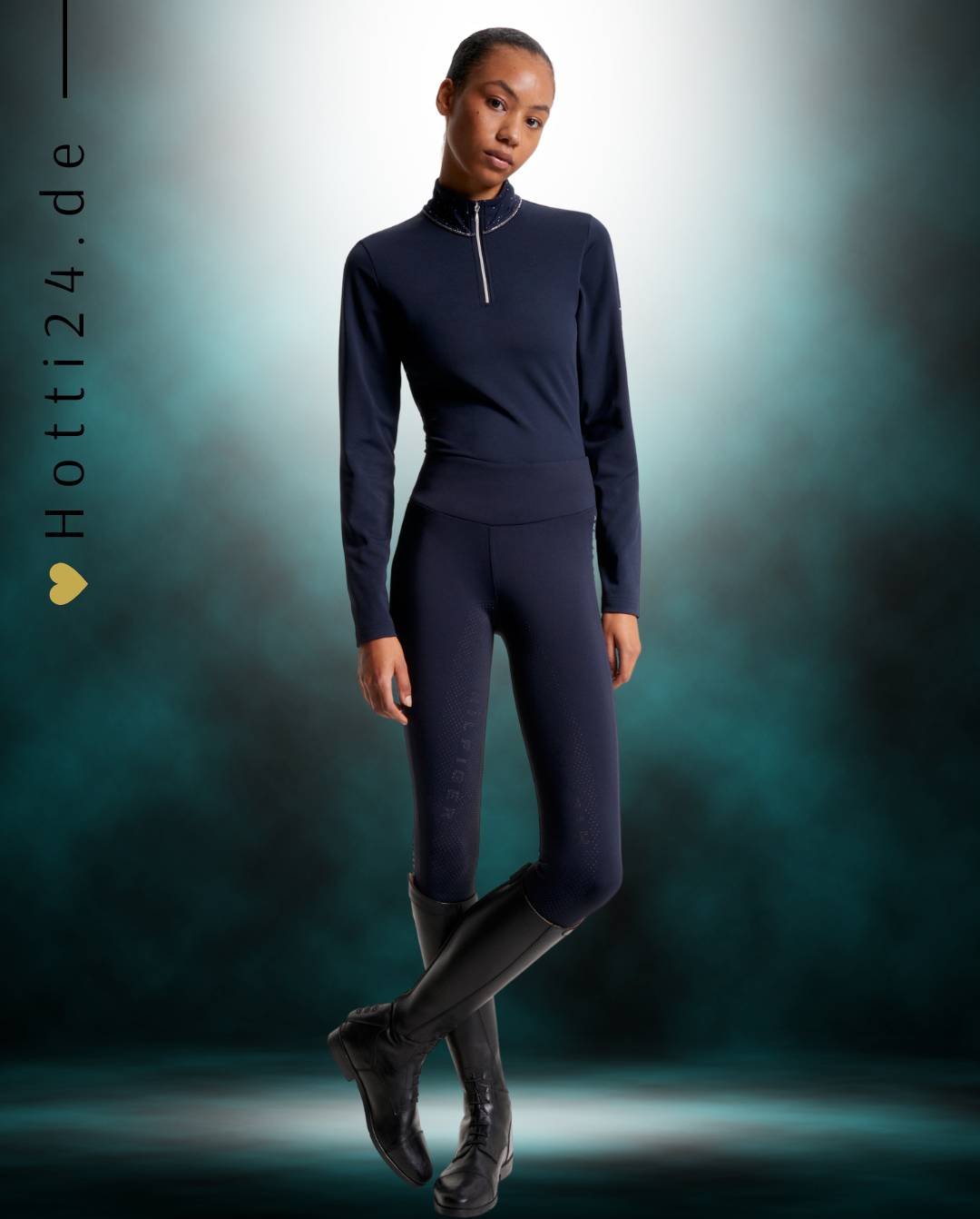 Damen-Trainingshirt von Tommy Hilfiger mit der Bezeichnung "Thermo Studded TH08WLZT434-004" in der Farbe Blau. Dieses Trainingshirt ist auf der Webseite www.hotti24.de erhältlich. Es wurde speziell für Damen entworfen, um Stil und Komfort während sportlicher Aktivitäten zu bieten.  Zusätzlich sind in der Datei Bilder des Trainingsshirts aus verschiedenen Blickwinkeln enthalten: von vorne, von der Seite und von hinten