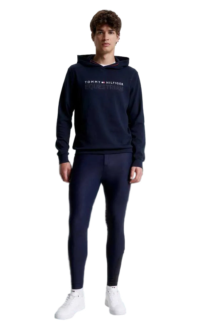 Die vorliegende Datei enthält Informationen über eine Herren-Reithose von Tommy Hilfiger mit dem Namen "Geneva Kniegrip TH08MKBR487-004" in der Farbe Blau. Diese Reithose ist auf der Website www.hotti24.de erhältlich. Die Hose verfügt über Kniegriff-Elemente, die zusätzlichen Halt bieten. Es sind Bilder der Reithose aus verschiedenen Blickwinkeln enthalten: von vorne, von der Seite und von hinten.