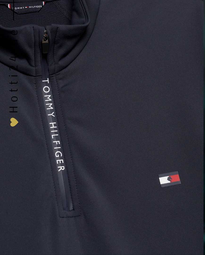Herren-Trainingshirt von Tommy Hilfiger mit der Bezeichnung "Thermo TH08MLZS471-042" in der Farbe Grau. Das Trainingshirt ist auf der Webseite www.hotti24.de verfügbar. Dieses spezielle Shirt wurde entwickelt, um während des Trainings Wärme zu bieten und gleichzeitig Komfort zu gewährleisten. In der Datei sind auch Bilder des Trainingshemds aus verschiedenen Blickwinkeln enthalten, einschließlich der Vorderseite, der Seite und der Rückseite.