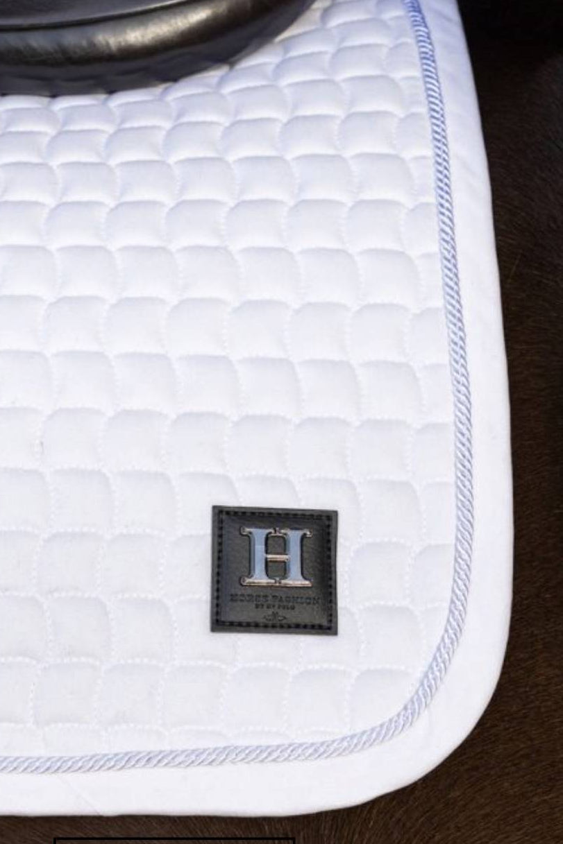Pferde Dressurschabracke "Dae" von HV POLO in der Farbe Weiß mit der Artikelnummer 0802093512-0001. Diese Dressurschabracke wurde speziell entwickelt, um Ihrem Pferd während der Dressur einen eleganten und komfortablen Sitz zu bieten. Sie können diese Pferde Dressurschabracke auf der Website www.hotti24.de erwerben.