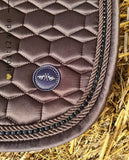 Pferde Dressurschabracke "Marena" von HV POLO in der Farbe Braun mit der Artikelnummer 0802093454-8026-DR. Diese Dressurschabracke wurde speziell entwickelt, um Ihrem Pferd während der Dressur einen eleganten und komfortablen Sitz zu bieten. Sie können diese Pferde Dressurschabracke auf der Website www.hotti24.de erwerben.