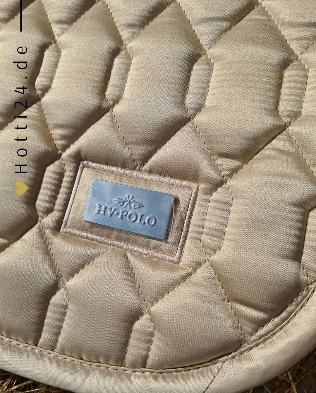 Pferde Vielseitigkeitsschabracke "Welmoed Simple Shine" von HV POLO in der Farbe Beige mit der Artikelnummer 0801093457-1015. Diese Schabracke wurde speziell entwickelt, um Ihrem Pferd während vielseitiger Reitaktivitäten einen eleganten und komfortablen Sitz zu bieten. Sie können diese Pferde Vielseitigkeitsschabracke auf der Website www.hotti24.de erwerben.