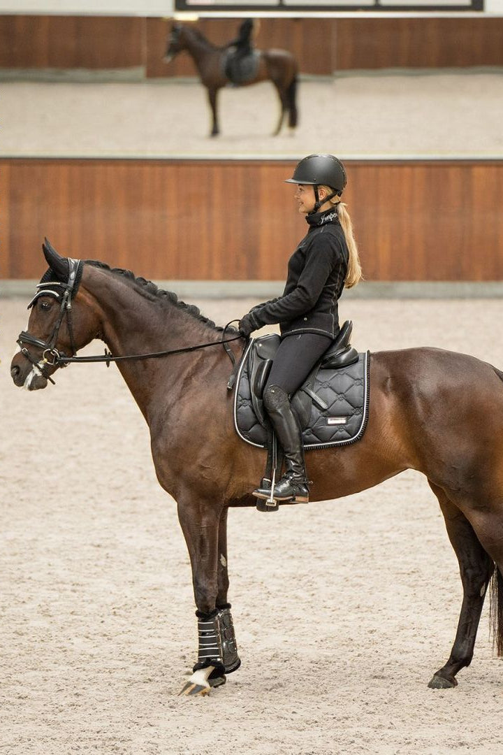 Imperial Riding präsentiert die Dressurschabracke IRH Lovely in der Farbe Schwarz mit der Artikelnummer ZT78122000-9000. Diese Dressurschabracke vereint Stil und Funktionalität und eignet sich ideal für Dressuraktivitäten. Für weitere Informationen und die Möglichkeit zum Kauf besuchen Sie bitte die Website www.Hotti24.de