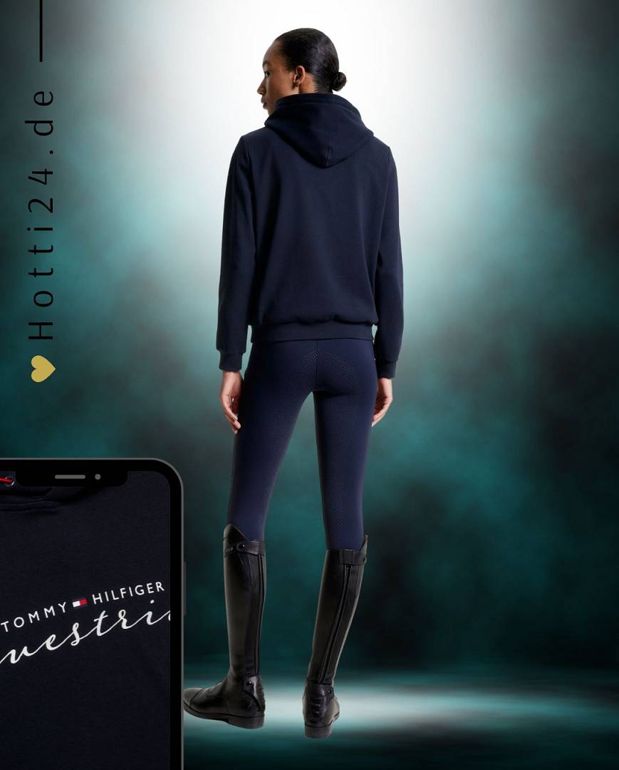 Damen-Hoodie von Tommy Hilfiger mit der Bezeichnung "Metallic TH08WHOO438-004" in der Farbe Blau. Dieser Hoodie ist auf der Webseite www.hotti24.de erhältlich. Er wurde speziell für Damen entworfen, um sowohl Stil als auch Komfort zu bieten. Die Datei enthält auch Bilder des Hoodies aus verschiedenen Blickwinkeln, darunter die Vorderseite, die Seite und die Rückseite. Diese visuellen Darstellungen ermöglichen es Ihnen, das Design und die Eigenschaften des Hoodies besser zu verstehen