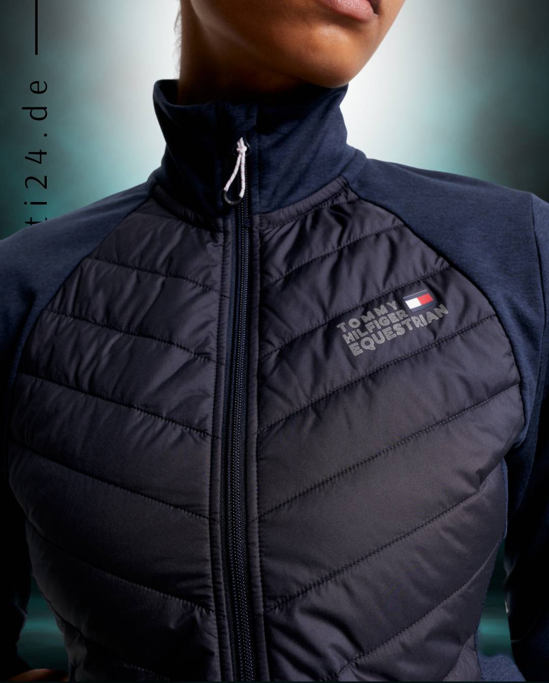 Damen-Hybridjacke von Tommy Hilfiger mit der Bezeichnung "Hybridjacke TH08WJAC454-004" in der Farbe Blau. Diese Hybridjacke ist auf der Webseite www.hotti24.de erhältlich. Sie wurde speziell für Damen entworfen, um sowohl Stil als auch Funktionalität zu bieten.  Zusätzlich sind in der Datei Bilder der Hybridjacke aus verschiedenen Blickwinkeln enthalten: von vorne, von der Seite und von hinten. 