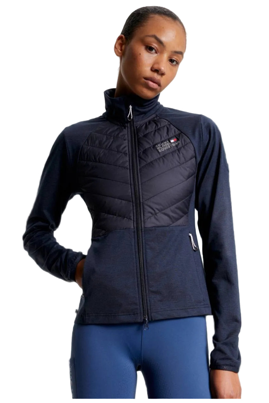 Damen-Hybridjacke von Tommy Hilfiger mit der Bezeichnung "Hybridjacke TH08WJAC454-004" in der Farbe Blau. Diese Hybridjacke ist auf der Webseite www.hotti24.de erhältlich. Sie wurde speziell für Damen entworfen, um sowohl Stil als auch Funktionalität zu bieten.  Zusätzlich sind in der Datei Bilder der Hybridjacke aus verschiedenen Blickwinkeln enthalten: von vorne, von der Seite und von hinten. 