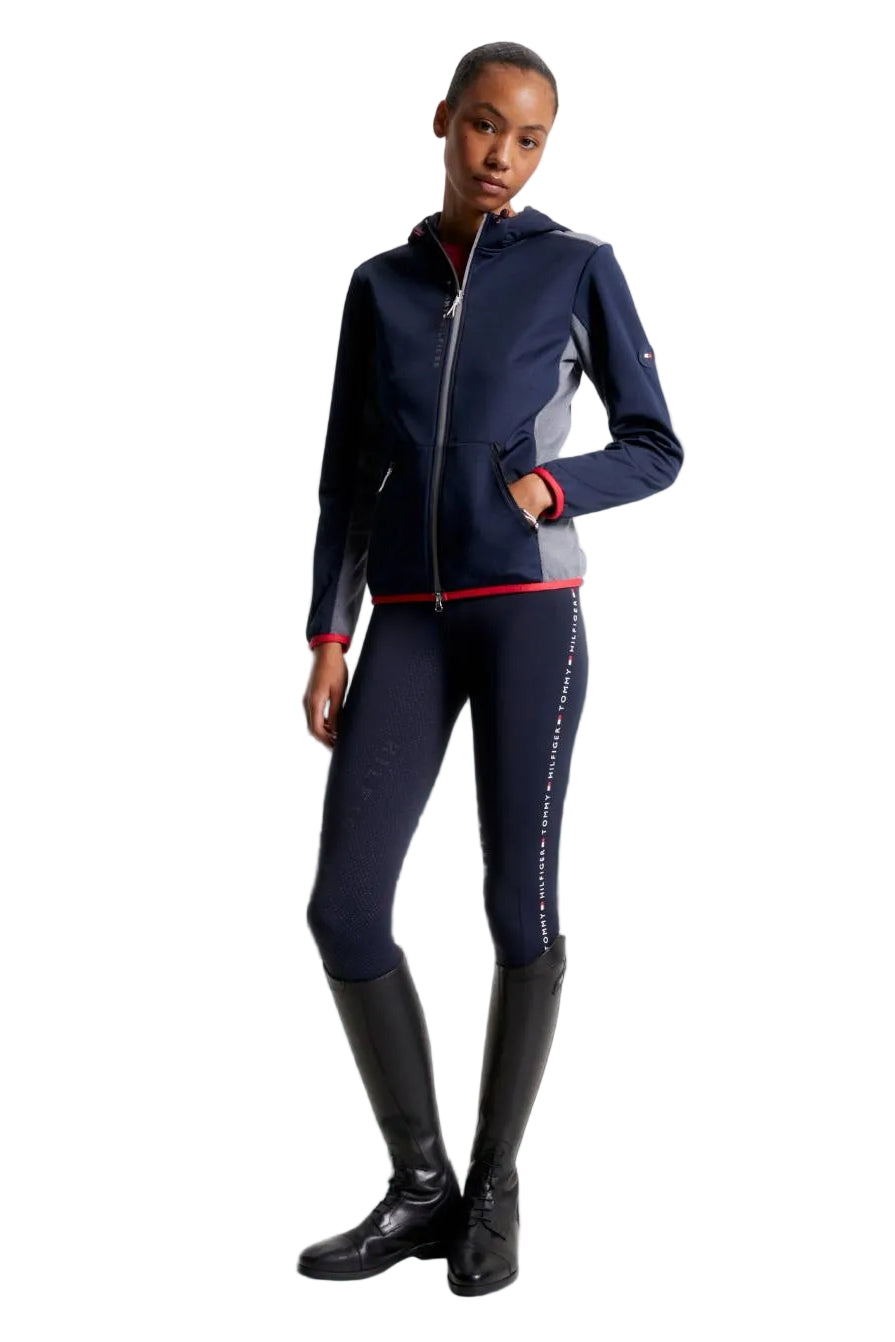 Damen-Jacke im Softshell-Stil von Tommy Hilfiger mit der Bezeichnung "Softshell Jacke London TH08WJAC451-004" in der Farbe Blau. Diese Softshell-Jacke ist auf der Webseite www.hotti24.de erhältlich. Sie wurde speziell für Damen entworfen, um sowohl Stil als auch Schutz vor den Elementen zu bieten.  Zusätzlich sind in der Datei Bilder der Softshell-Jacke aus verschiedenen Blickwinkeln enthalten: von vorne, von der Seite und von hinten. 