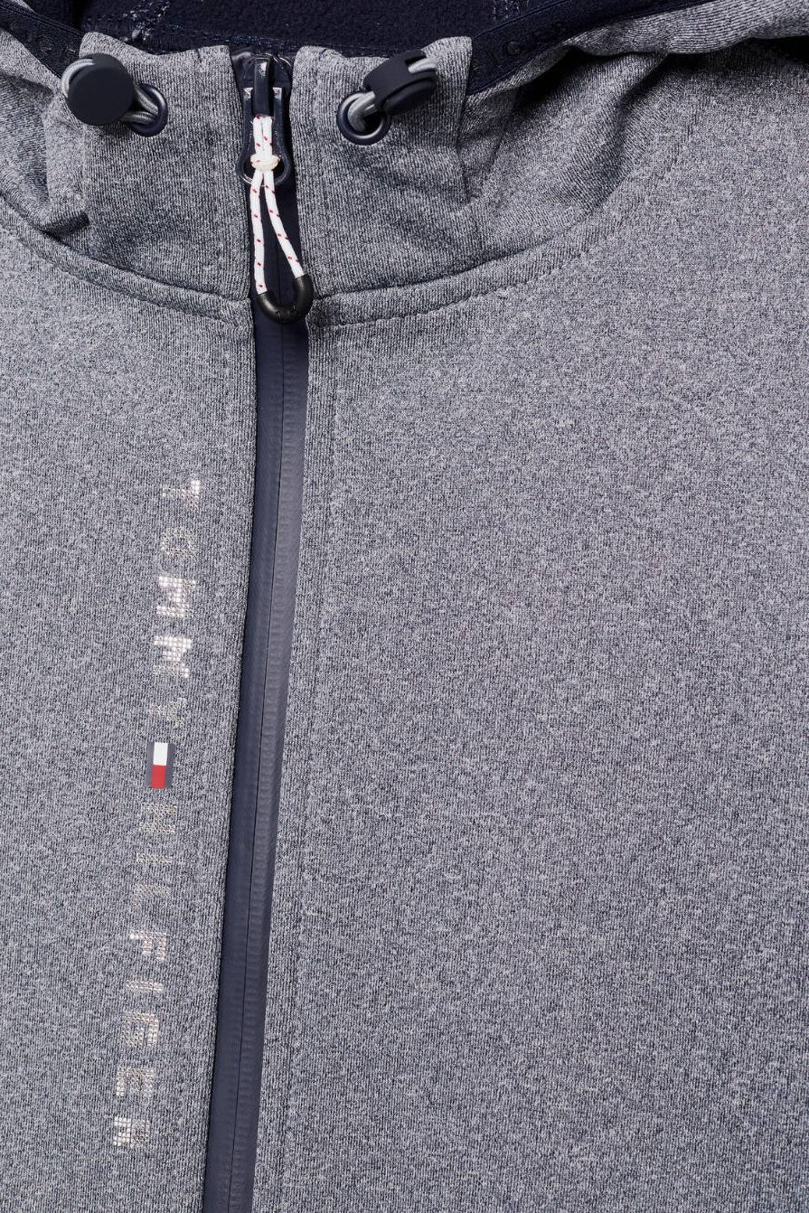 Damen-Jacke im Softshell-Stil von Tommy Hilfiger mit der Bezeichnung "Softshell Jacke London TH08WJAC451-027" in der Farbe Grau. Diese Softshell-Jacke ist auf der Webseite www.hotti24.de erhältlich. Sie wurde speziell für Damen entworfen, um sowohl Stil als auch Schutz vor den Elementen zu bieten.  Zusätzlich sind in der Datei Bilder der Softshell-Jacke aus verschiedenen Blickwinkeln enthalten: von vorne, von der Seite und von hinten
