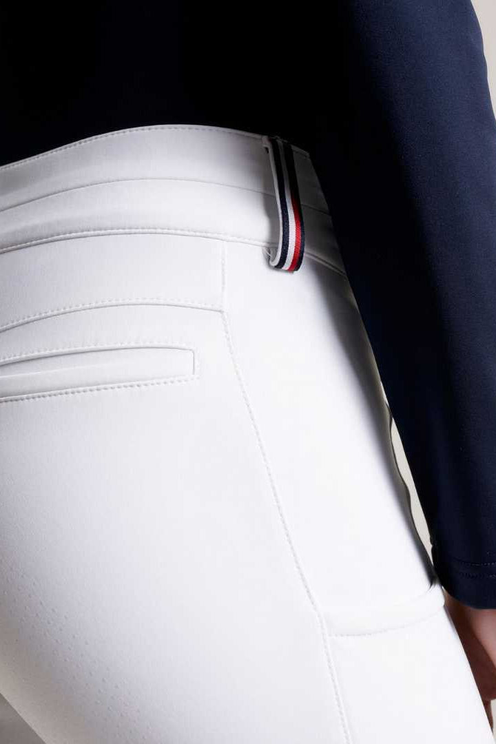 Damen-Reithose von Tommy Hilfiger mit der Bezeichnung "Geneva Fullgrip TH08WFBR464-001" in der Farbe Weiß. Diese Reithose ist auf der Webseite www.hotti24.de erhältlich. Die Hose wurde speziell für Damen entworfen und verfügt über Fullgrip-Elemente, die zusätzlichen Halt während des Reitens bieten sollen.