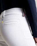 Damen-Reithose von Tommy Hilfiger mit der Bezeichnung "Geneva Fullgrip TH08WFBR464-001" in der Farbe Weiß. Diese Reithose ist auf der Webseite www.hotti24.de erhältlich. Die Hose wurde speziell für Damen entworfen und verfügt über Fullgrip-Elemente, die zusätzlichen Halt während des Reitens bieten sollen.