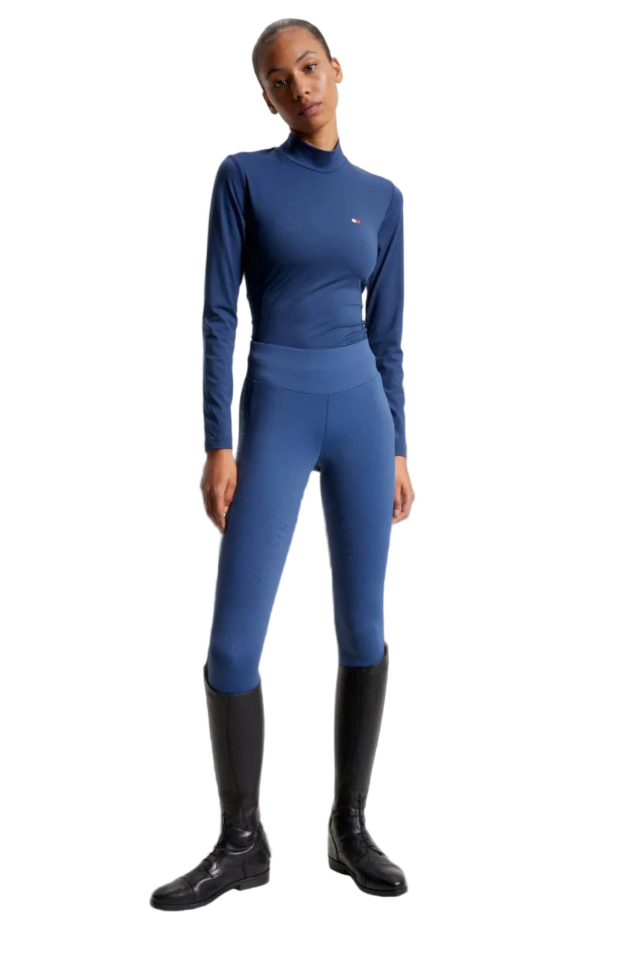 Damen-Trainingshirt von Tommy Hilfiger mit der Bezeichnung "Baselayer TH08WLST432-041" in der Farbe Blau. Dieses Trainingshirt ist auf der Webseite www.hotti24.de erhältlich. Es wurde speziell für Damen entworfen, um Stil und Komfort während sportlicher Aktivitäten zu bieten.  Zusätzlich sind in der Datei Bilder des Trainingsshirts aus verschiedenen Blickwinkeln enthalten: von vorne, von der Seite und von hinten.
