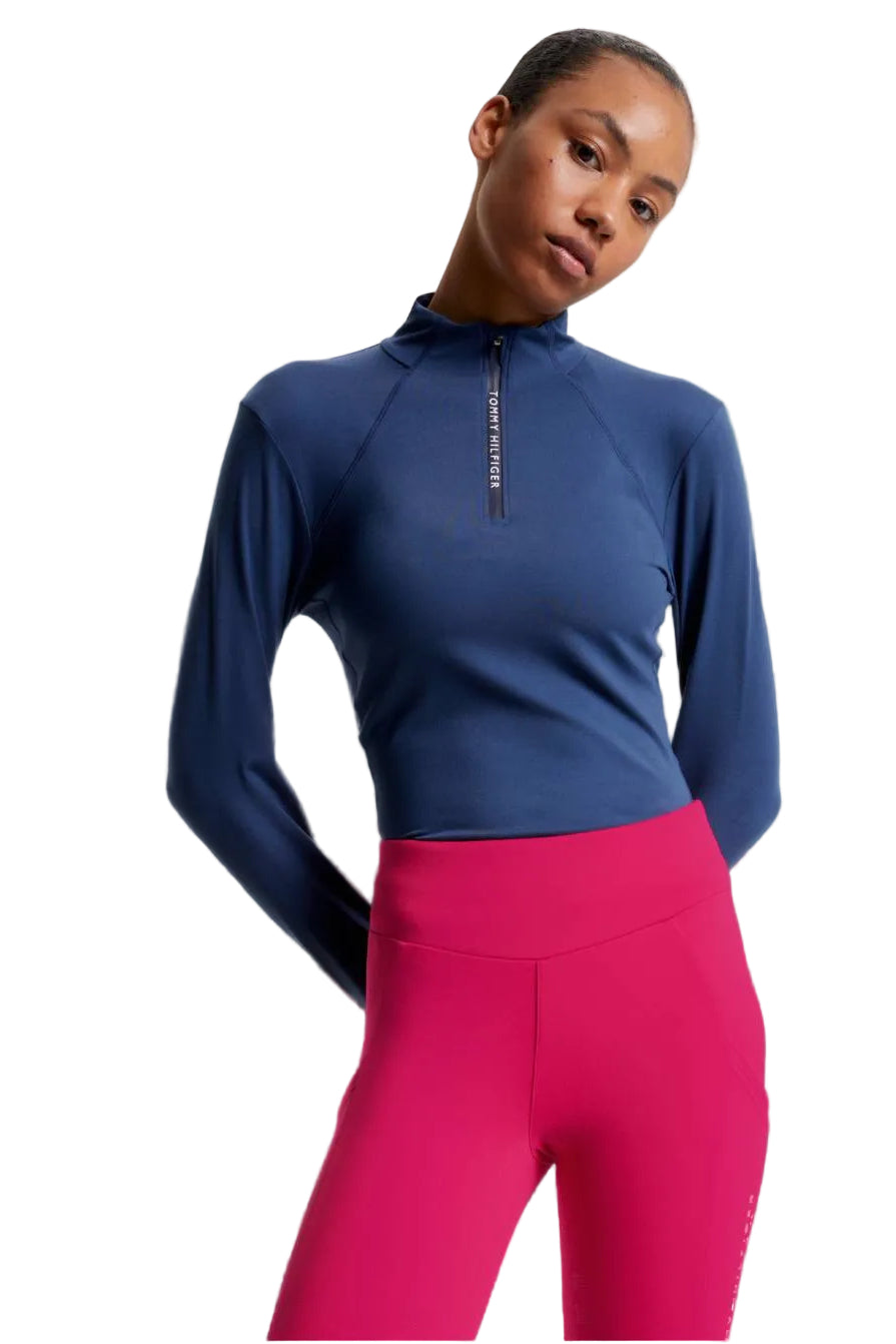 Damen-Trainingshirt von Tommy Hilfiger mit der Bezeichnung "Thermo Baselayer TH08WLZT433-041" in der Farbe Blau. Dieses Trainingshirt ist auf der Webseite www.hotti24.de erhältlich. Es wurde speziell für Damen entworfen, um Stil und Komfort während sportlicher Aktivitäten zu bieten.  Zusätzlich sind in der Datei Bilder des Trainingsshirts aus verschiedenen Blickwinkeln enthalten: von vorne, von der Seite und von hinten