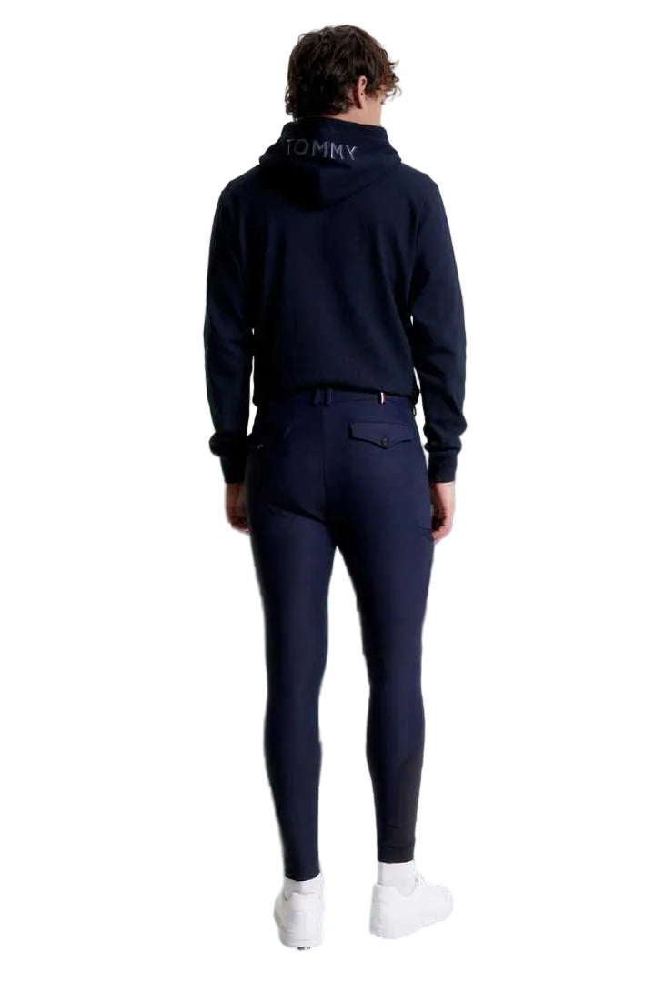 Die vorliegende Datei enthält Informationen über eine Herren-Reithose von Tommy Hilfiger mit dem Namen "Geneva Kniegrip TH08MKBR487-004" in der Farbe Blau. Diese Reithose ist auf der Website www.hotti24.de erhältlich. Die Hose verfügt über Kniegriff-Elemente, die zusätzlichen Halt bieten.  Es sind Bilder der Reithose aus verschiedenen Blickwinkeln enthalten: von vorne, von der Seite und von hinten. 
