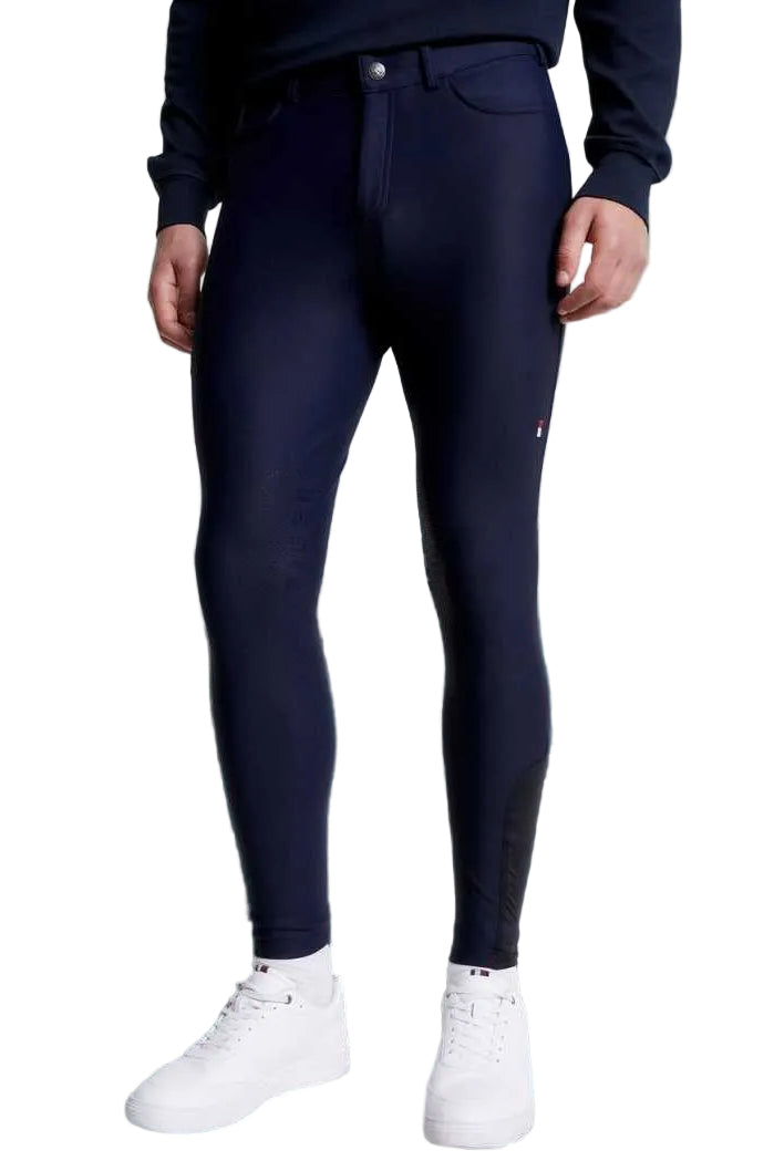 Die vorliegende Datei enthält Informationen über eine Herren-Reithose von Tommy Hilfiger mit dem Namen "Geneva Kniegrip TH08MKBR487-004" in der Farbe Blau. Diese Reithose ist auf der Website www.hotti24.de erhältlich. Die Hose verfügt über Kniegriff-Elemente, die zusätzlichen Halt bieten.  Es sind Bilder der Reithose aus verschiedenen Blickwinkeln enthalten: von vorne, von der Seite und von hinten. 