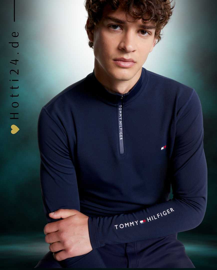 Herren-Trainingshirt von Tommy Hilfiger mit der Bezeichnung "Thermo TH08MLZS471-004" in der Farbe Blau. Dieses Trainingshirt ist auf der Website www.hotti24.de erhältlich. Das Shirt wurde speziell entwickelt, um während des Trainings Wärme zu bieten und gleichzeitig komfortabel zu bleiben.  Zusätzlich enthält die Datei Bilder des Trainingshemds aus verschiedenen Blickwinkeln, darunter die Vorderseite, die Seite und die Rückseite. 